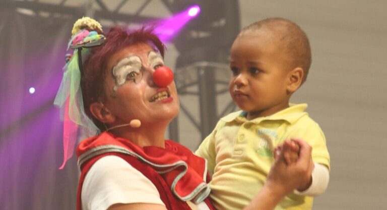 Photo d'Anita le clown. Elle porte un bébé dans ses bras