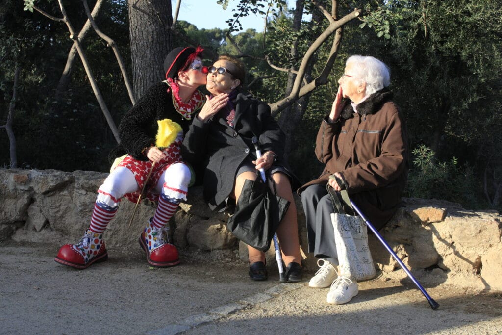 Photo d'Anita le Clown faisant un bisou a une mamie dans un parc