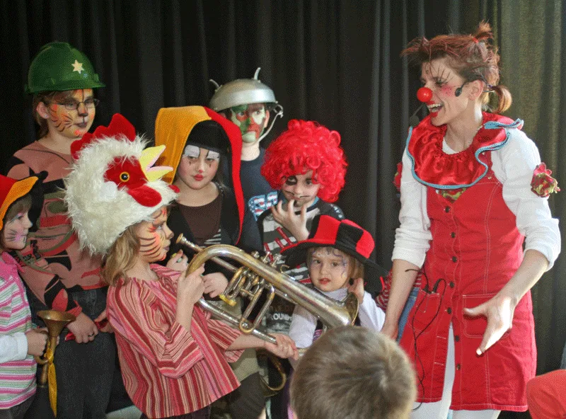 Photo d'un anniversaire. Anita le clown est avec les enfants et les instruments